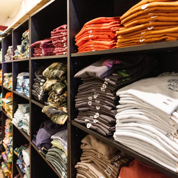 Shelves filled with neatly folded t-shirts and sweatshirts in various colors and patterns.