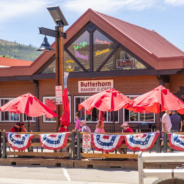 Butterhorn Bakery & Cafe with outdoor patio seating, red umbrellas, and American flag bunting.