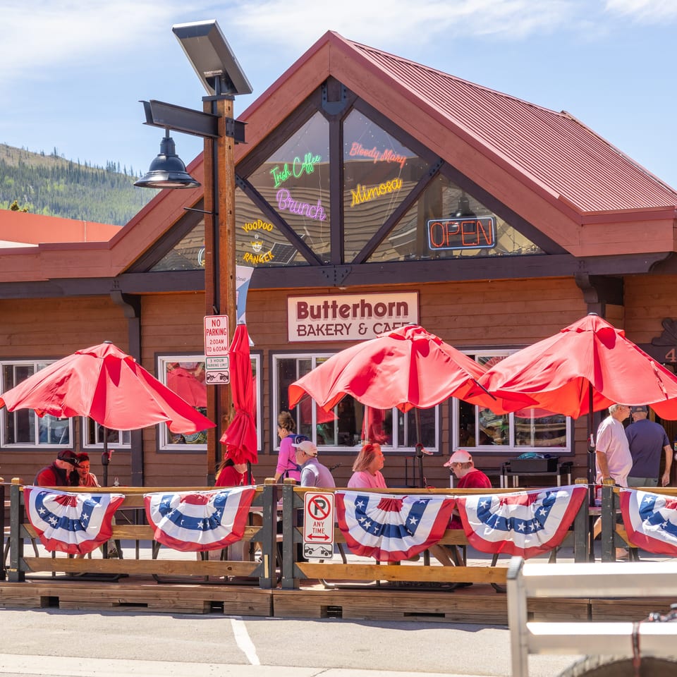 Butterhorn Bakery & Cafe with outdoor patio seating, red umbrellas, and American flag bunting.